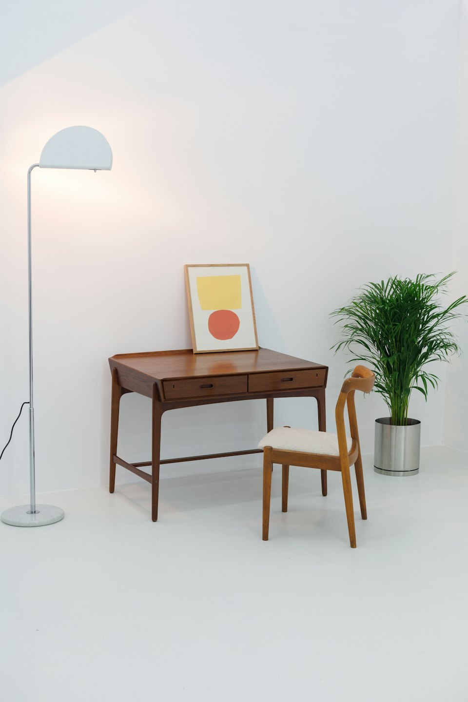 Bureau style mid-century moderne avec une plante et une œuvre d'art abstraite.