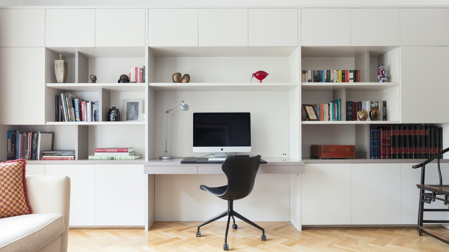 Bureau moderne avec étagères blanches et bureau d'ordinateur.