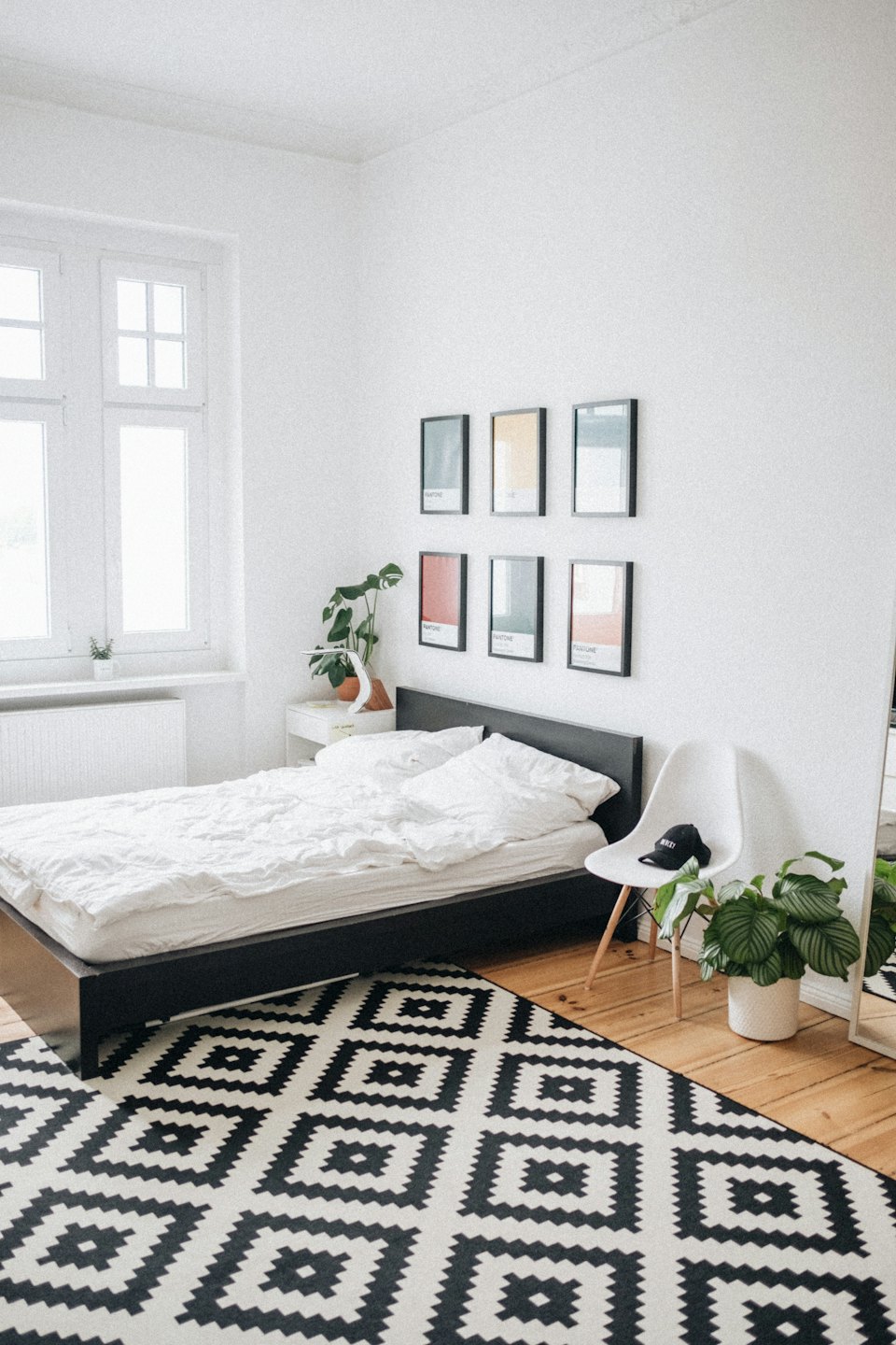 Chambre moderne avec plantes et tapis géométrique.