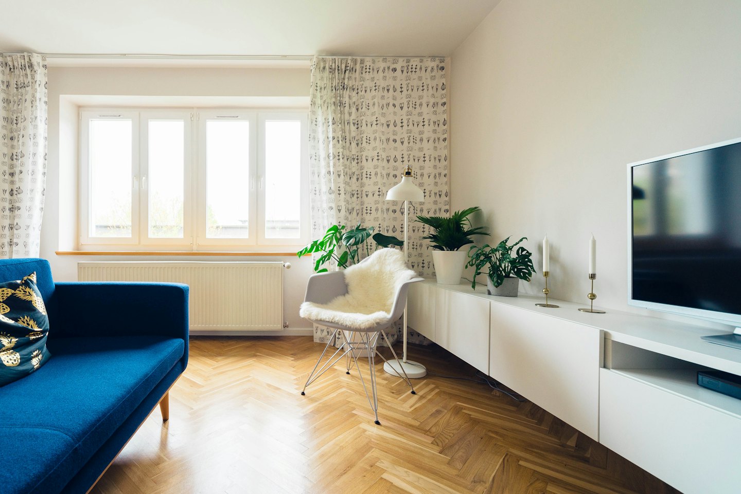 Salon moderne avec un canapé bleu et un fauteuil blanc.