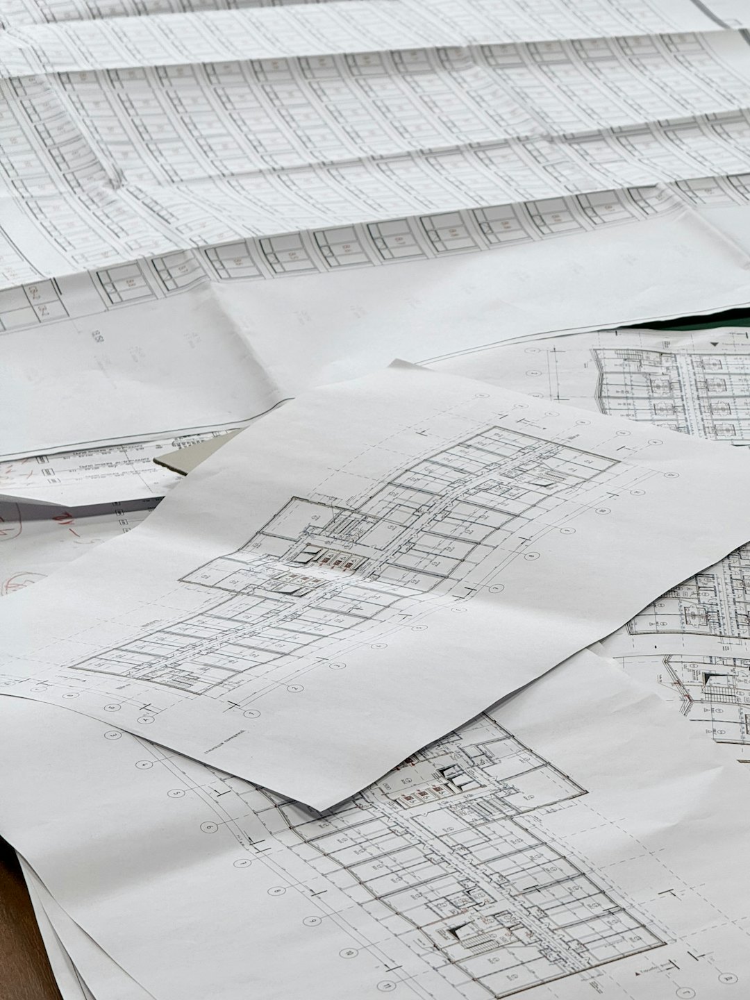 Plans d'architecte et plans d'étage étalés sur une surface plane.